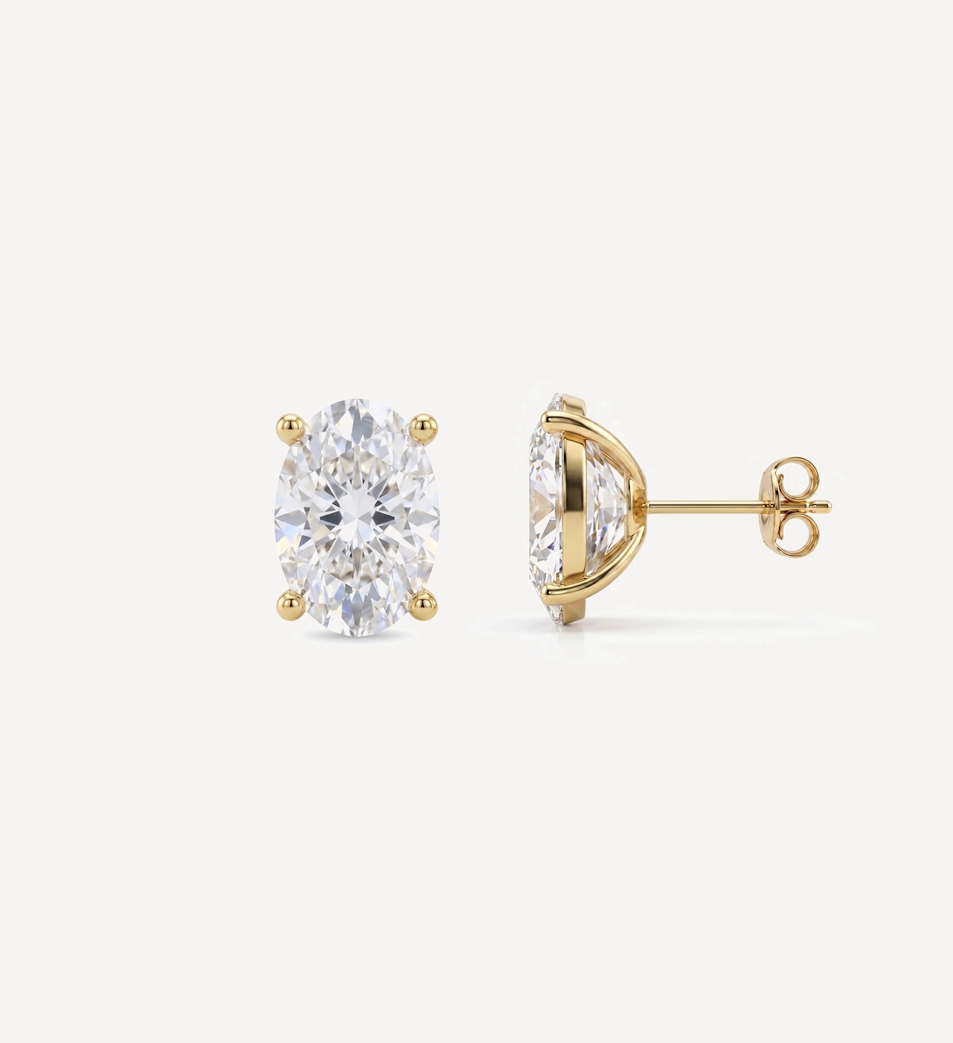 Large Oval Grace diamond stud earrings in yellow gold featuring oval brilliant-cut diamonds, shown in front and side profile with a four-prong setting and butterfly back
