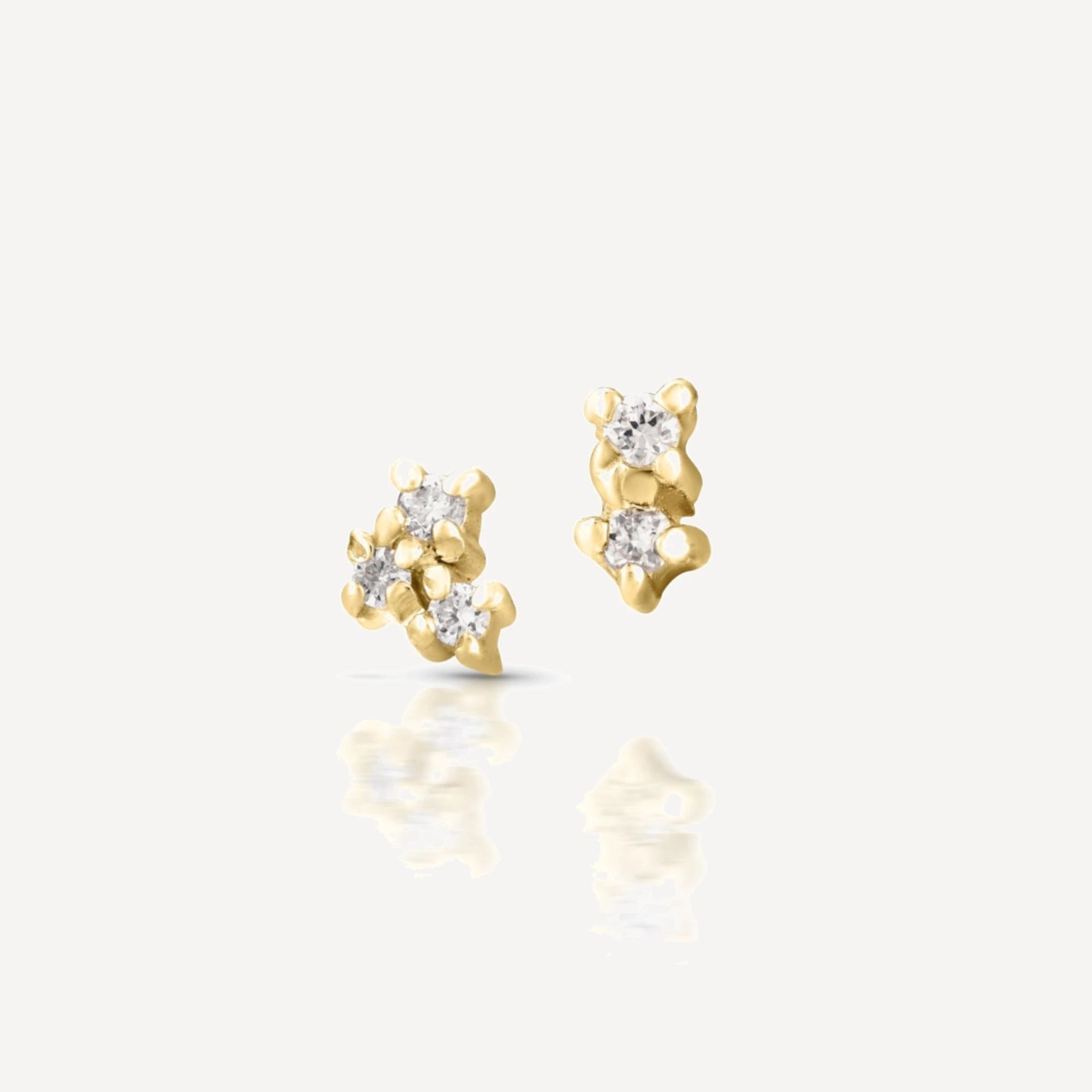 Yellow gold diamond cluster stud earrings featuring a delicate multi-stone floral cluster design with brilliant-cut diamonds on a soft beige background.