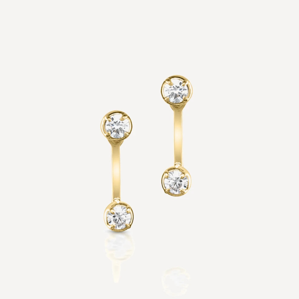 Yellow gold diamond stud earrings with matching adjustable diamond jacket featuring brilliant-cut diamonds in a contemporary ear jacket design on a soft beige background.