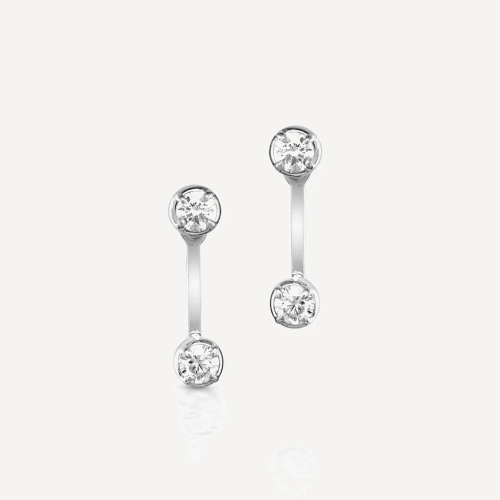 Sterling silver diamond stud earrings with matching adjustable diamond jacket featuring brilliant-cut diamonds in a modern ear jacket design on a soft beige background.
