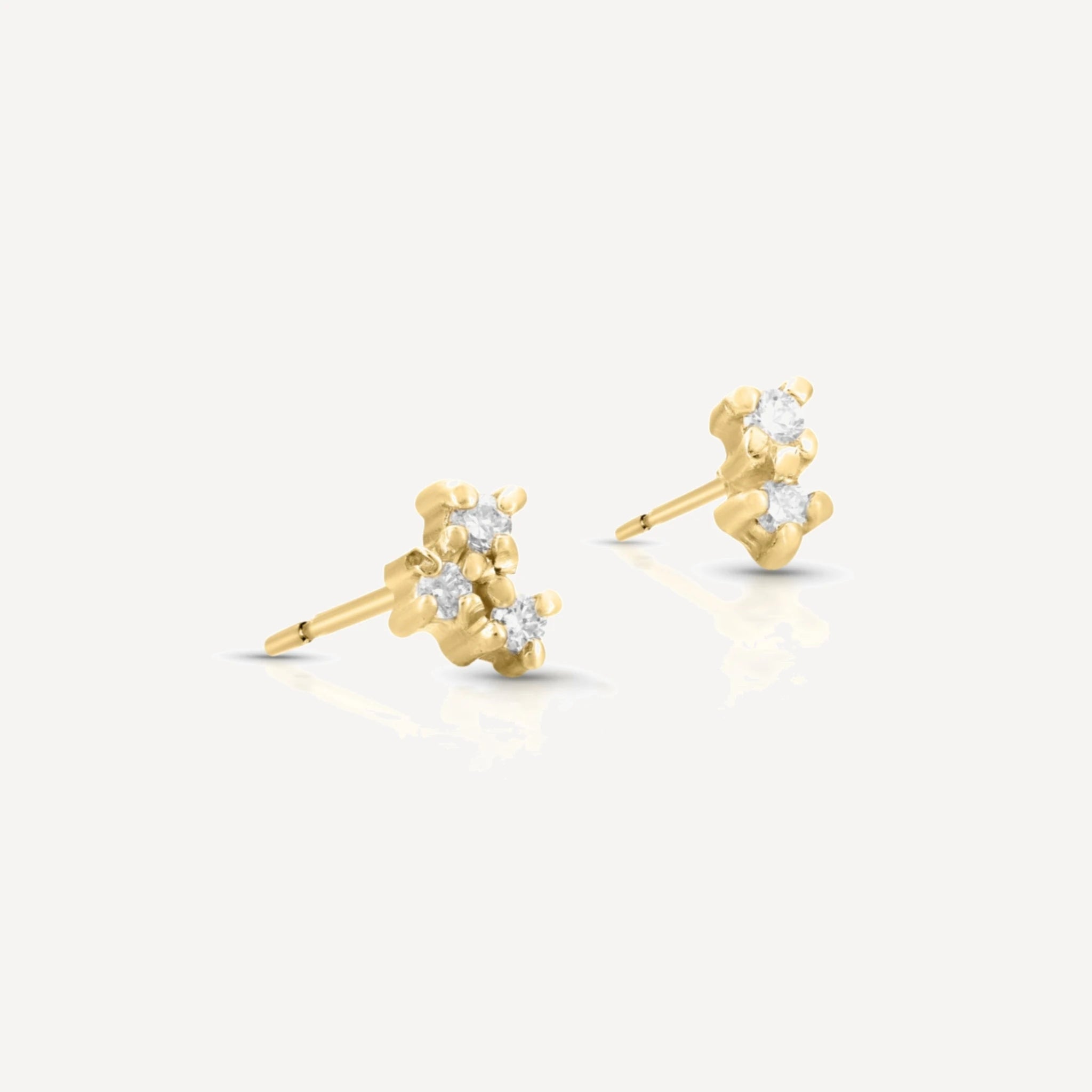 Yellow gold diamond cluster stud earrings featuring a delicate multi-stone floral cluster design with brilliant-cut diamonds on a soft beige background.