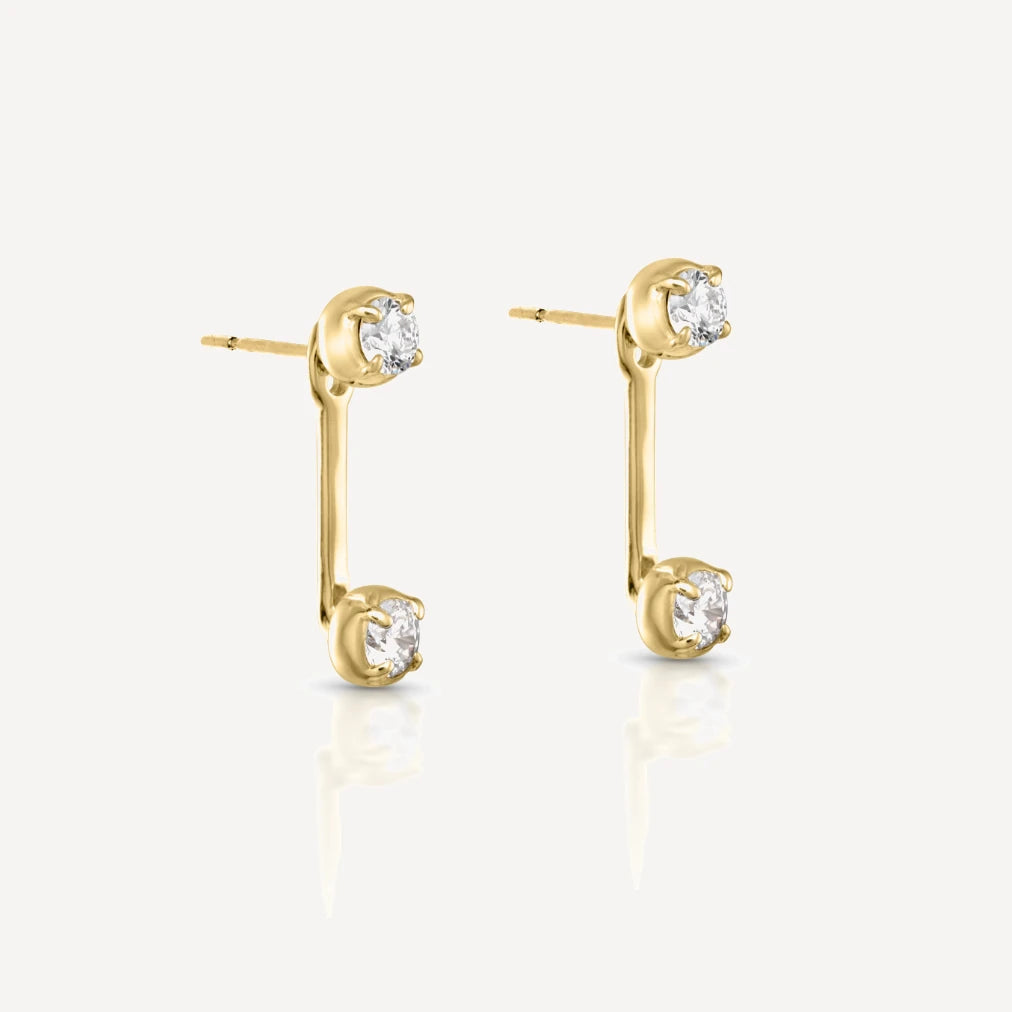 Yellow gold diamond stud earrings with matching adjustable diamond jacket featuring brilliant-cut diamonds in a contemporary ear jacket design on a soft beige background.